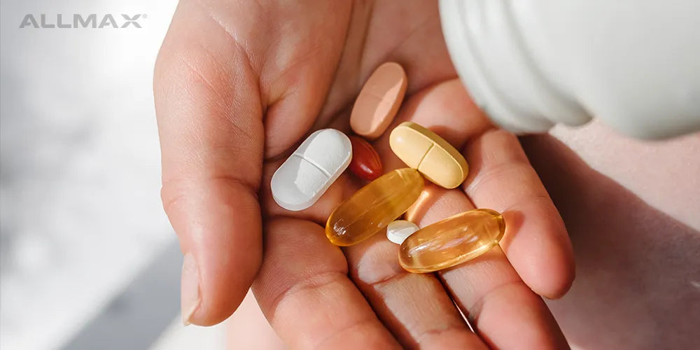 a hand holding supplements and vitamins