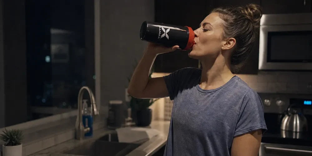 a woman drinking a protein shake before bed
